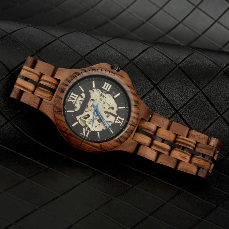 Wooden wristwatch on black textured surface.