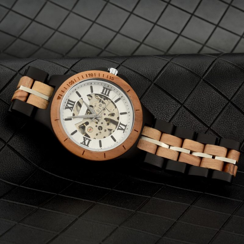 Wooden wristwatch with visible gears on leather surface.