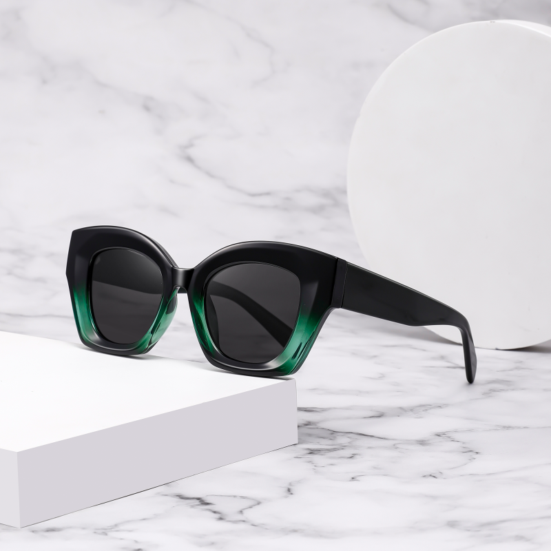 Black sunglasses with green gradient on marble background.