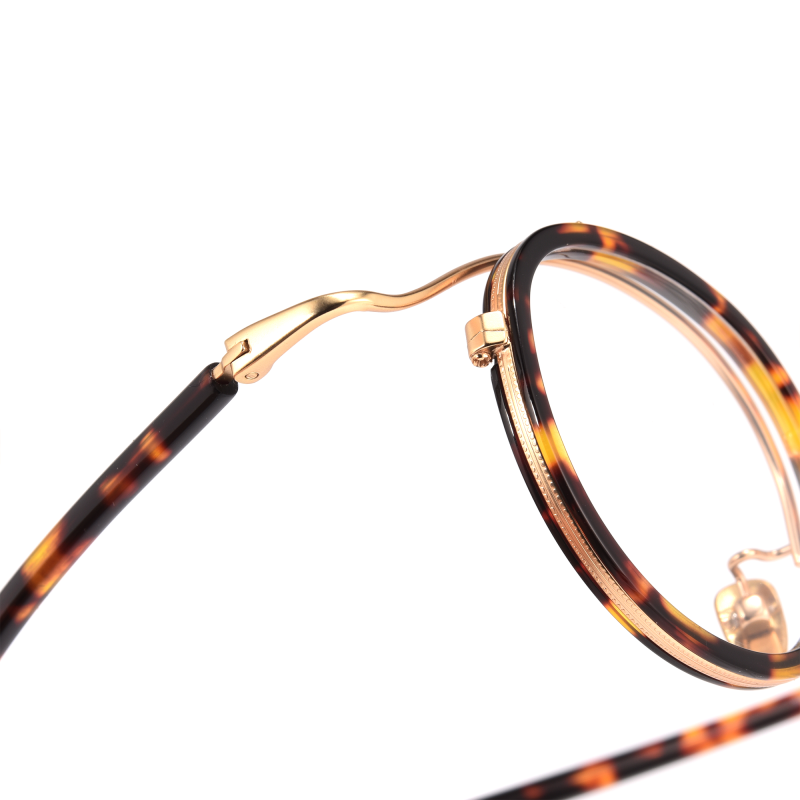Close-up of tortoiseshell eyeglasses with gold detailing.