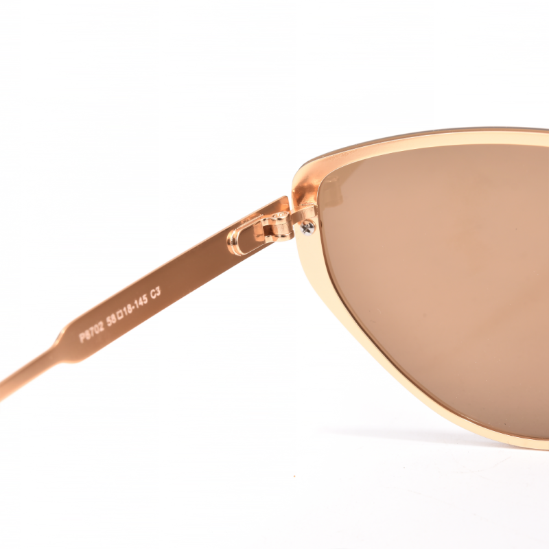 Close-up of gold sunglasses frame and lens.